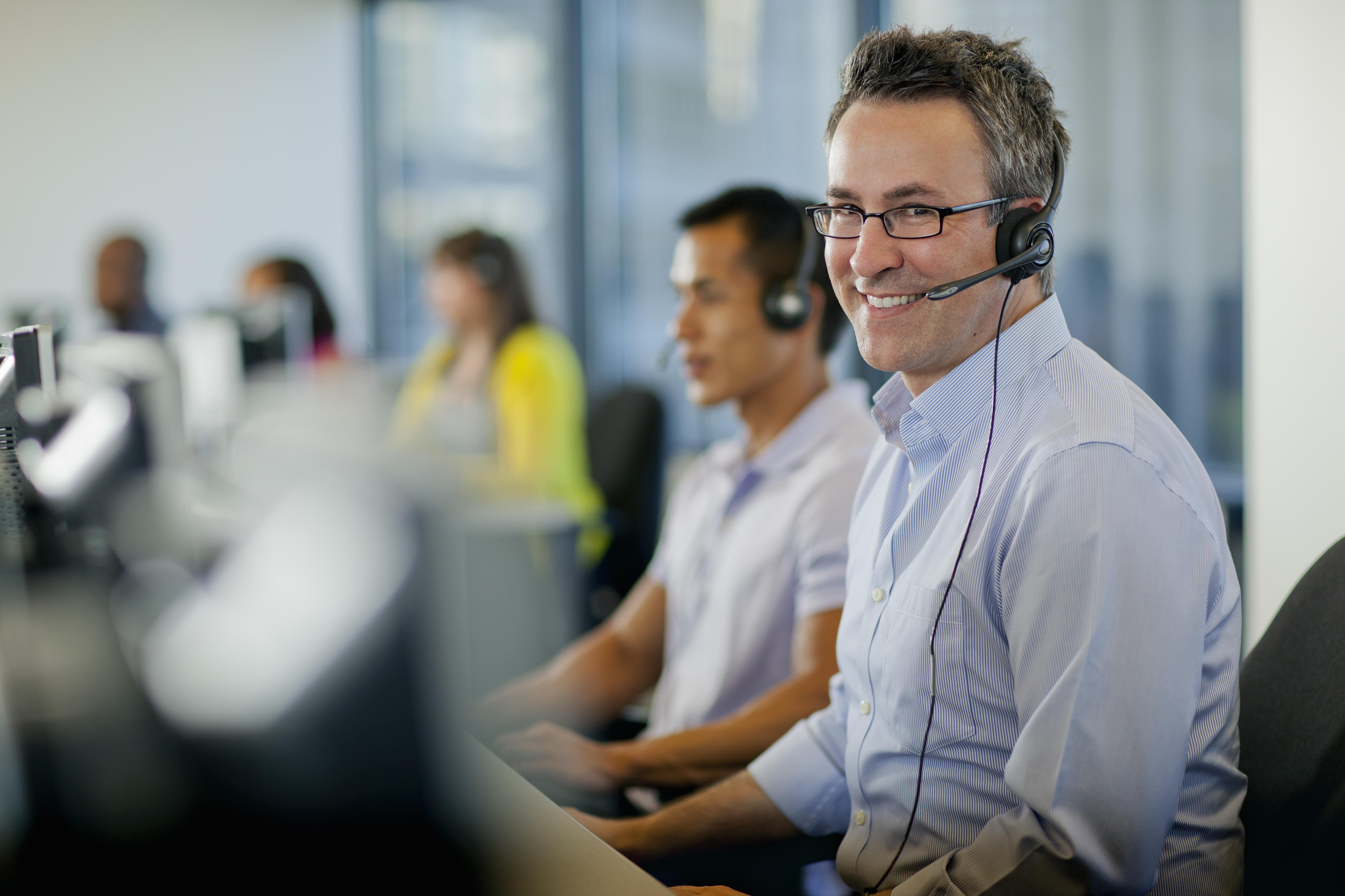 Smiling man with headset at customer center