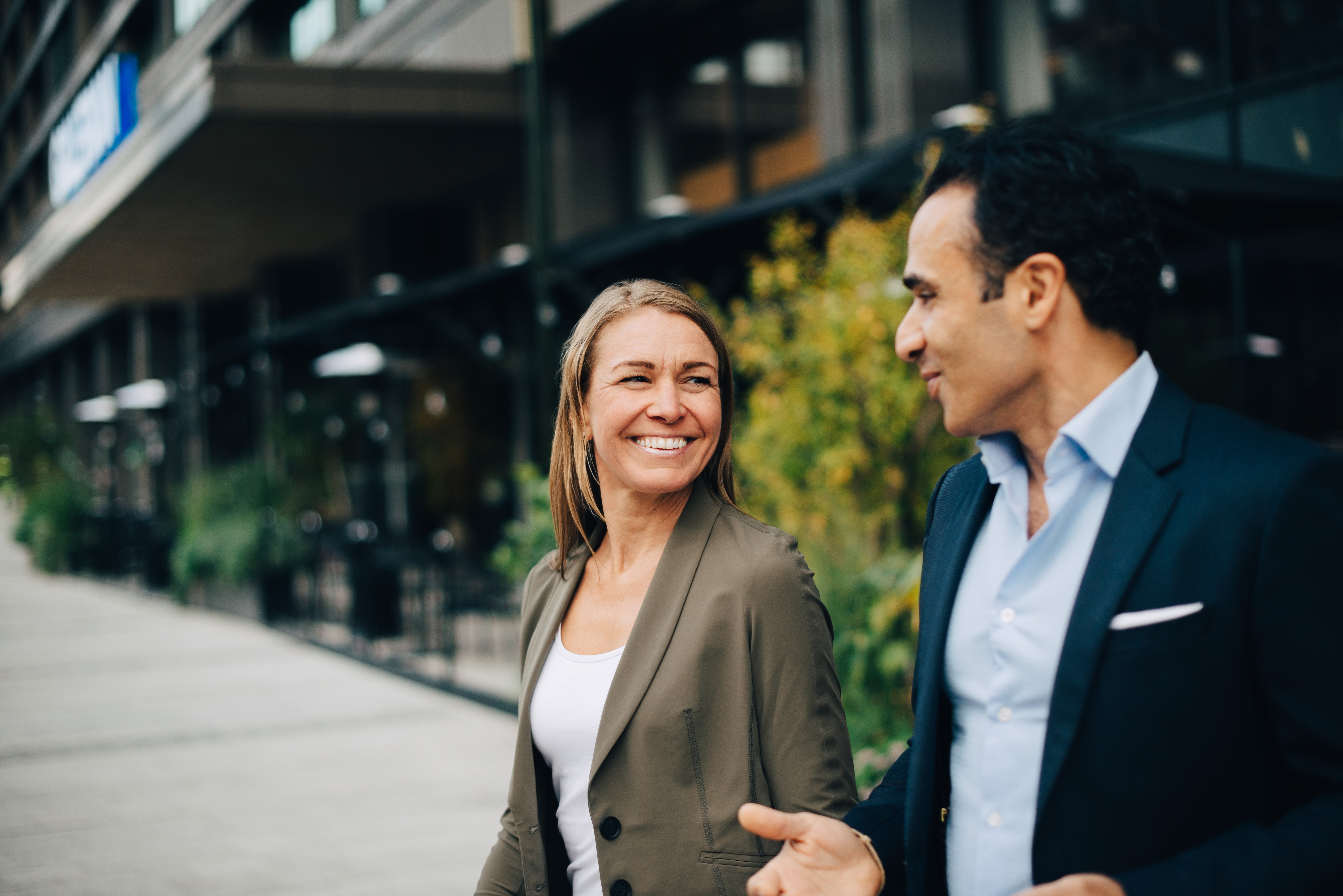 Buissness man and woman talking and laughing on a walk outdoors